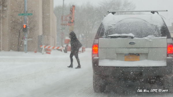 Pedestrian and SUV in snowy conditions.